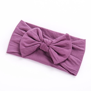 Close-up of soft purple nylon baby headband with a textured knitted large bow knot