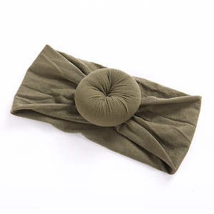Detail of army green nylon baby headband featuring a soft donut knot texture