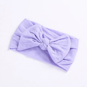 Detailed close-up of a soft light purple nylon baby headband with a large bow detail