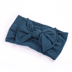 Close-up of dark blue elastic bow headband for infants showing soft fabric texture
