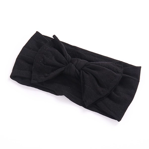 Close-up of a soft black wide headband for babies featuring a large handmade bow knot