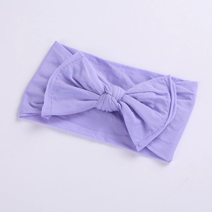 Detail view of seamless purple elastic baby headband with soft fabric knotted bow