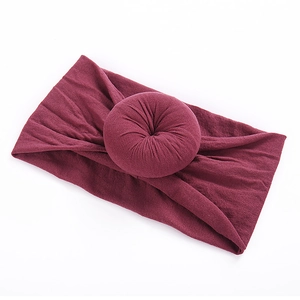 Close-up of soft burgundy nylon baby headband featuring a knit donut knot design