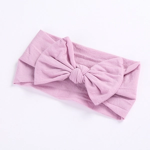 Detailed close-up of soft lavender knitted nylon baby headband with a large bow design