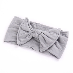 Detailed view of grey bow headband for babies made of soft and elastic cotton fabric