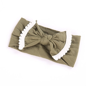 Olijfgroene gebreide babyhoofdband met grote strik en witte pom-pon kanten afwerking