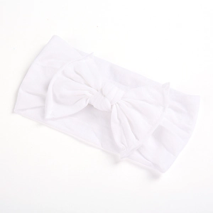 Macro shot of white soft nylon baby headband with a handcrafted oversized bow detail