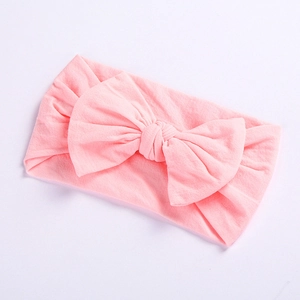 Detail of soft pink baby nylon headband featuring a large elastic knitted bow ornament