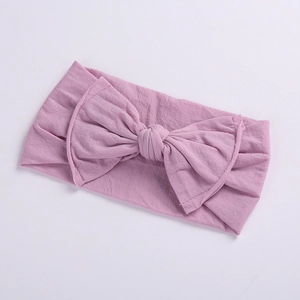 Detail view of baby bow headband in dusty pink with soft elastic seamless fabric
