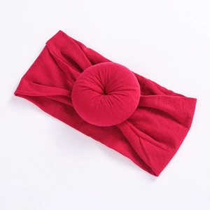 Detail of soft dark red nylon headband with elastic texture and a doughnut knot design