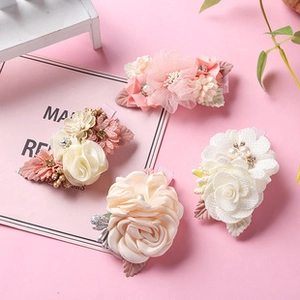 Close-up of four floral hair clips with 3D fabric flowers, pearls and rhinestones decoration