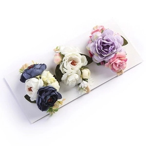 Detailed view of three DIY fabric flower hairbands with delicate mesh petals and green leaves