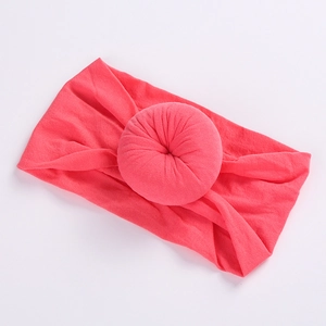 Detailed view of sweet donut nylon elastic baby headband in bright coral pink