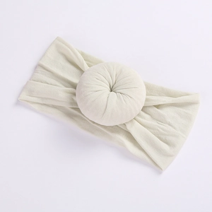 Detail of soft cream nylon elastic baby headband with ribbed texture and donut knot