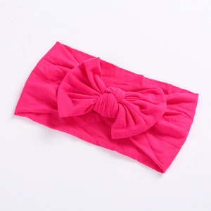Close-up of soft rose pink nylon headband with a large handmade bow for baby girls