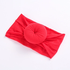 Detailed close-up of a vibrant red nylon donut-style elastic headband for babies