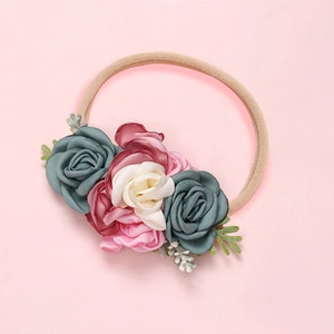Close-up of baby nylon headband with handcrafted satin flowers and soft pearls