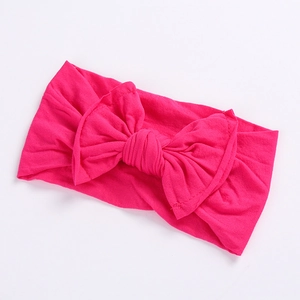 Detail of soft rose pink wide baby headband with large bow and elastic seamless fabric