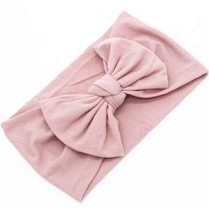 Close-up of pink nylon bow headband showing soft knit texture for babies and infants