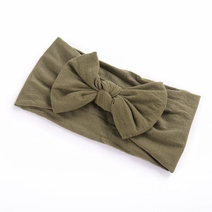 Olive green nylon headband for babies featuring a large decorative bow on a white background