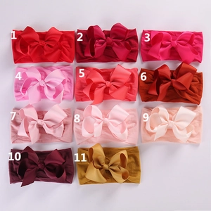 Flat lay of 11 colorful baby bow headbands featuring soft nylon straps and grosgrain texture