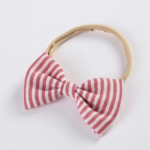 Détail d'un nœud en tissu rayé rouge et blanc sur un bandeau en nylon souple pour bébé
