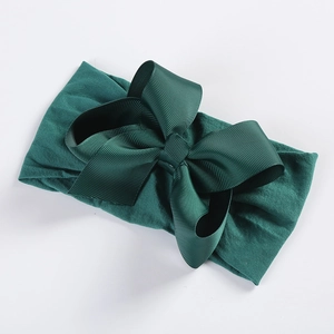 Detail of soft nylon dark green headband featuring a large textured grosgrain ribbon bow