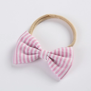 Détail d'un nœud à rayures roses et d'un bandeau en nylon ultra-souple pour bébés filles