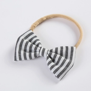Détail d'un bandeau bébé en nylon doux avec un nœud papillon en coton à rayures noir et blanc