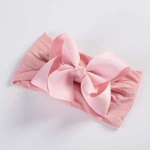 Detailed view of pink grosgrain ribbon bow on a soft nylon baby headband