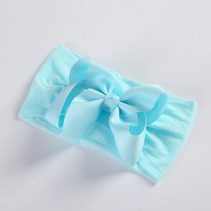 Detail showing light blue grosgrain ribbon bow on a soft nylon baby headband