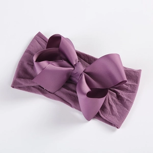 Close-up of deep purple baby headband with soft nylon base and oversized ribbed bow