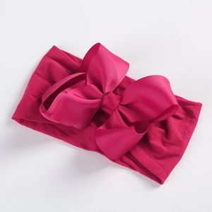 Detailed macro view of magenta grosgrain ribbon bow on soft nylon baby headband