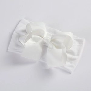 Detailed macro view of a 5-inch white ribbed ribbon bow on a soft nylon baby headband