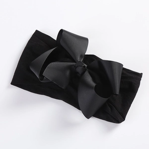 Detail of 5-inch black grosgrain ribbon bow on ultra-soft nylon elastic headband for kids