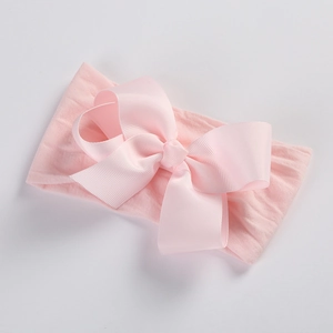 Close-up of soft pink nylon headband for baby girls with large ribbed grosgrain bow