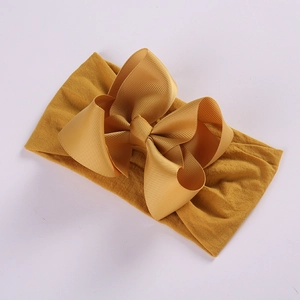 Detailed view of bright yellow high-elastic nylon headband with large grosgrain ribbon bow