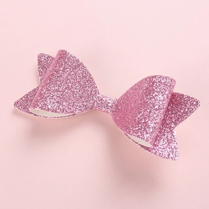 Detail einer pinkfarbenen Glitzerschleife mit funkelnder Textur und weißer Rückseite zum Basteln
