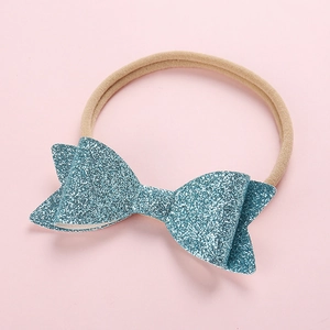Close-up of baby nylon headband featuring a blue sequin bow with glitter texture