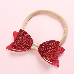 Bandeau bébé avec double nœud rouge pailleté et ruban en nylon doux en gros plan