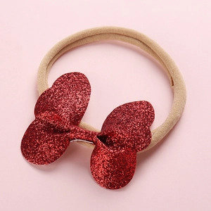 Détail d'un nœud à paillettes rouges sur un bandeau en nylon souple pour bébés