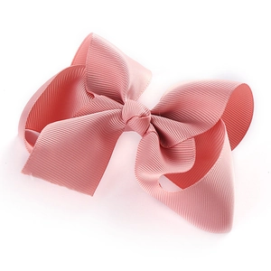 Detail der rosa Ripsband-Haarschleife mit gerippter Stoffstruktur und verknoteter Mitte