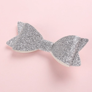 Makro-Detail einer silbernen Glitzerschleife für Haare mit schimmernder Pailletten-Textur