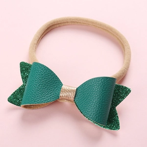 Bandeau bébé avec nœud vert pailleté multicouche et élastique en nylon sur fond rose doux