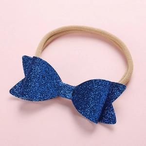 Detailed macro view of dark blue sequin bow and soft nylon headband for babies