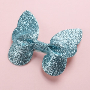 Sparkly blue glitter 3D butterfly hair clip for toddlers on a pink background