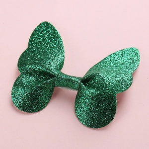 Close-up of a 3D green glitter butterfly hair accessory with sparkling sequins and fine texture