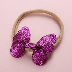 Détail d'un bandeau en nylon élastique avec un grand nœud papillon à paillettes violet