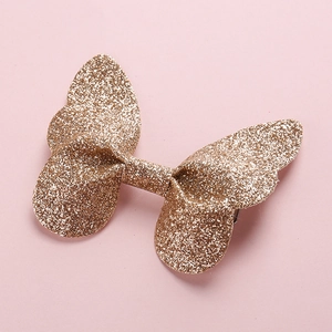 Close-up of golden glitter butterfly hair clip for kids with shimmering sequin details
