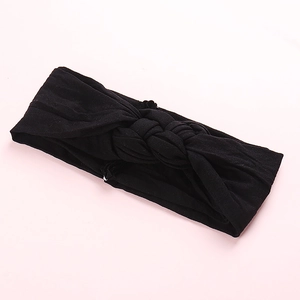 Détail d'un bandeau noir en nylon pour bébé avec un design croisé en maille douce et souple